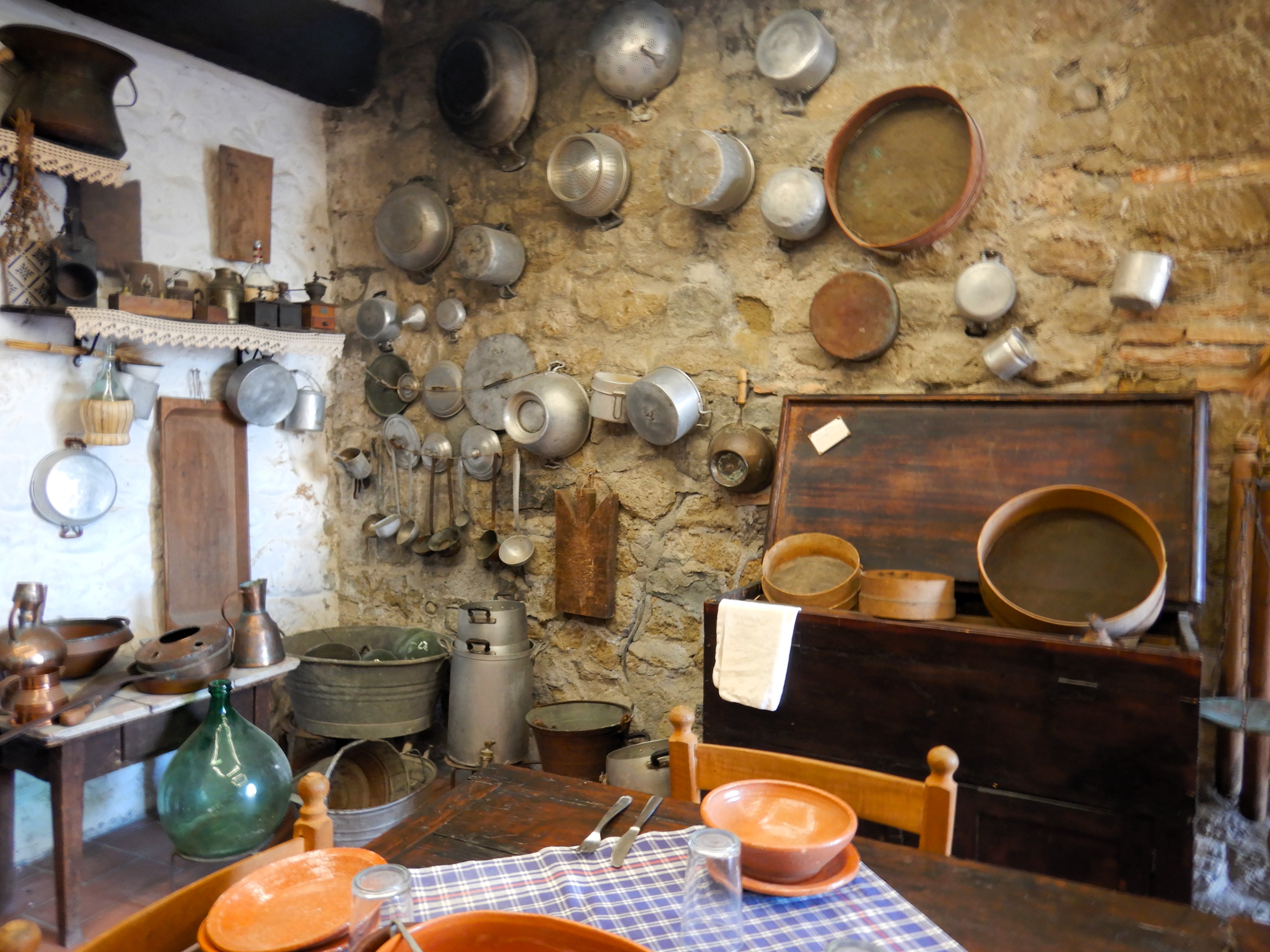 Interno di cucina contadina con madia, paioli, setacci e utensili appesi