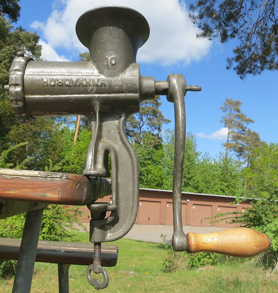 Tritacarne manuale Husqvarna del 1902 fissato correttamente al bordo di un tavolo